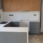 Μοντέρνα κουζίνα με γκρι και ξύλινα ντουλάπια.