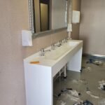 Καθρέφτης και πάγκος με νεροχύτες σε χώρο.