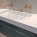 Μοντέρνος νεροχύτης με χρυσές βρύσες.